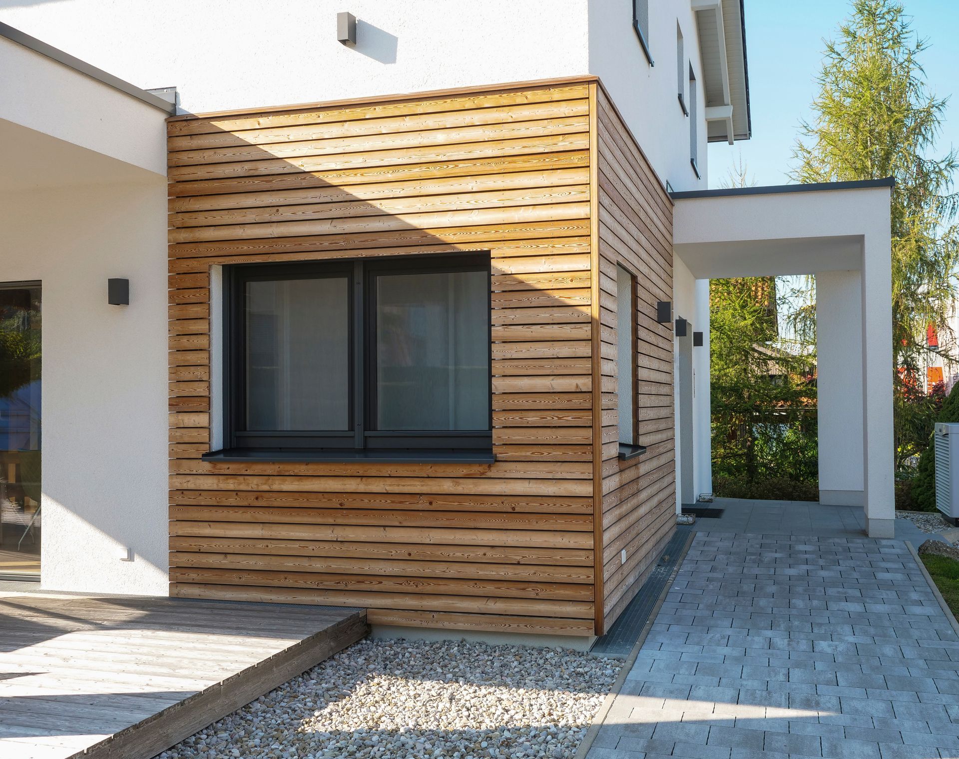 Exterior of a modern home with wood siding and a covered walkway.