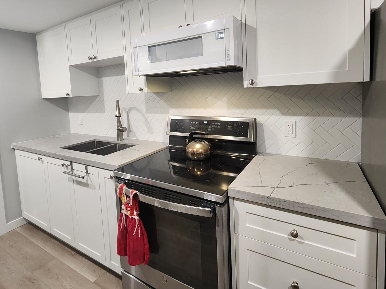 A kitchen with stainless steel appliances and white cabinets