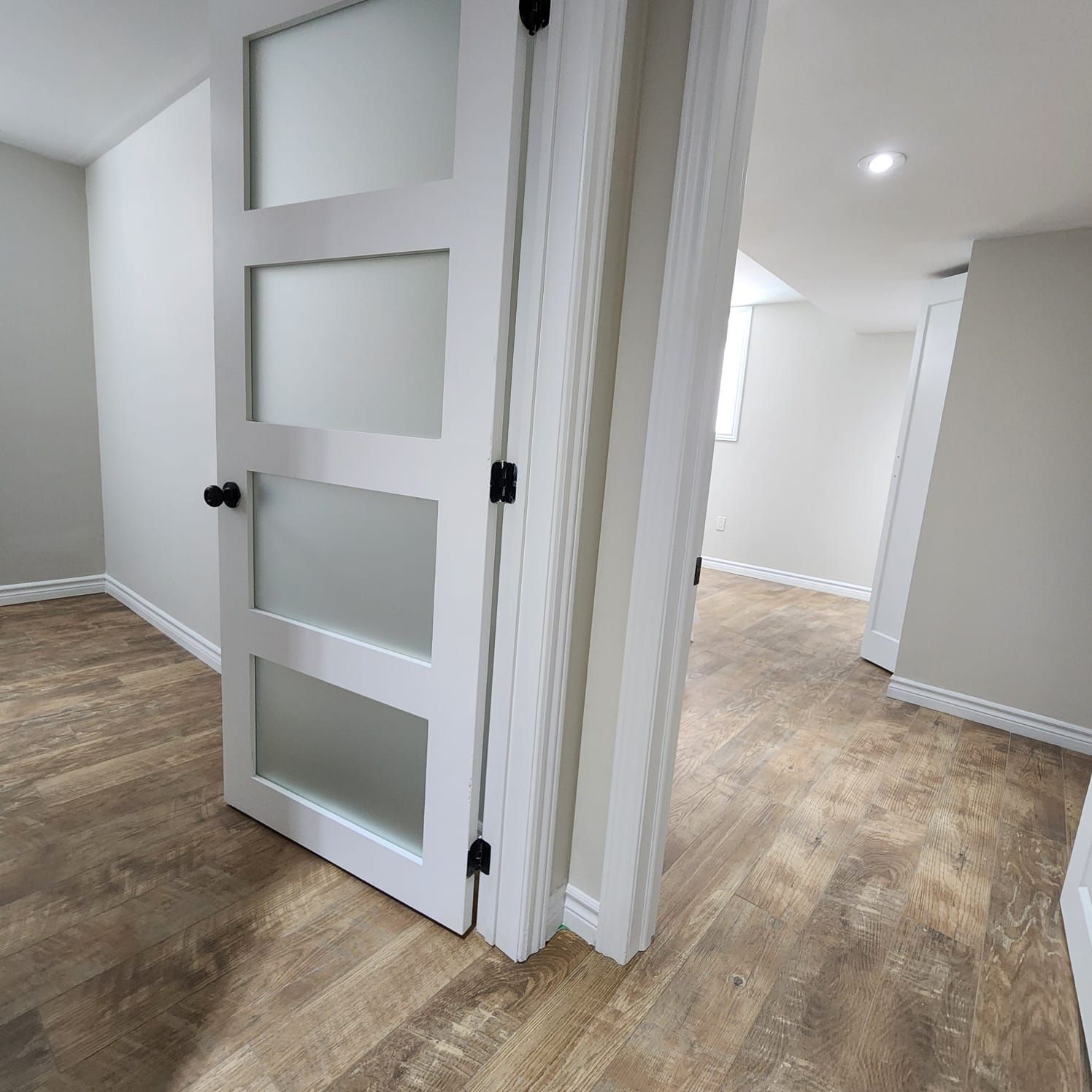 A room with a white door and a wooden floor