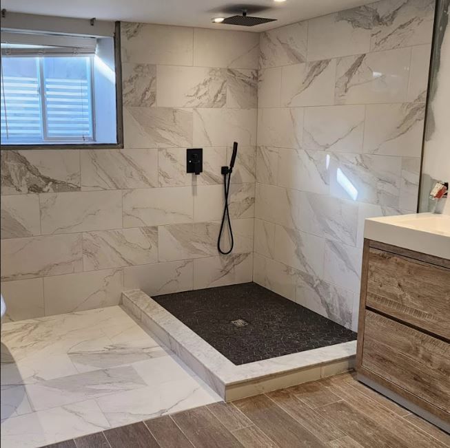A bathroom with a walk in shower and a sink.