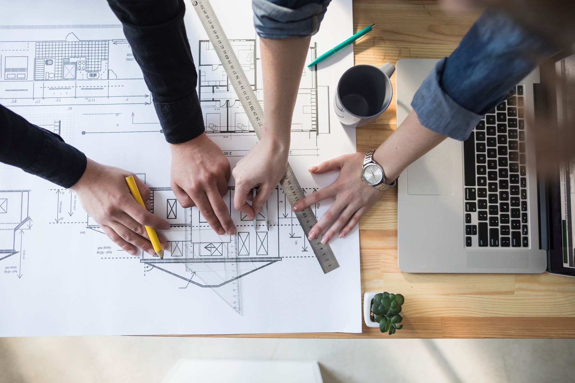 A group of people are working on a blueprint of a house.