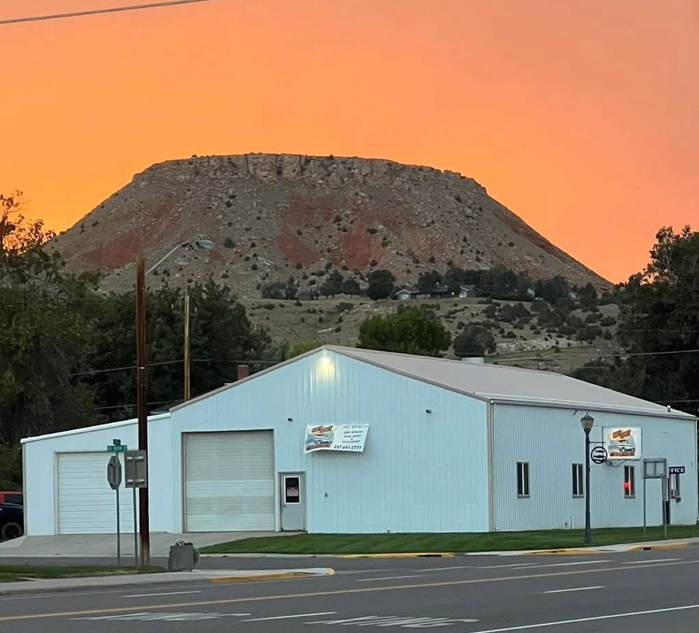 A building with a large mountain in the background during sunset.