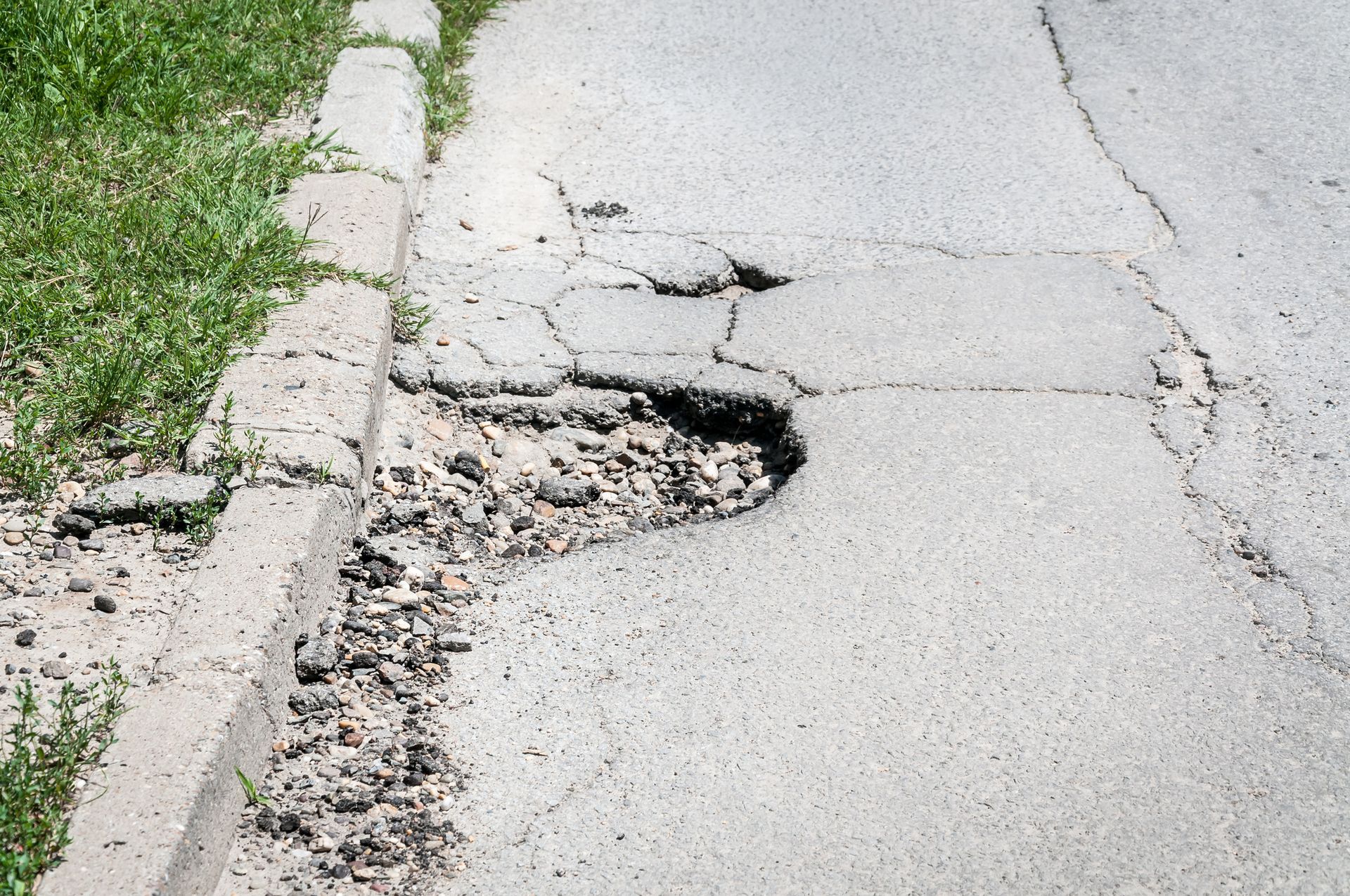 Driveway With Deep Pothole - Lee’s Summit, MO - Heartland Fence & Concrete Co.