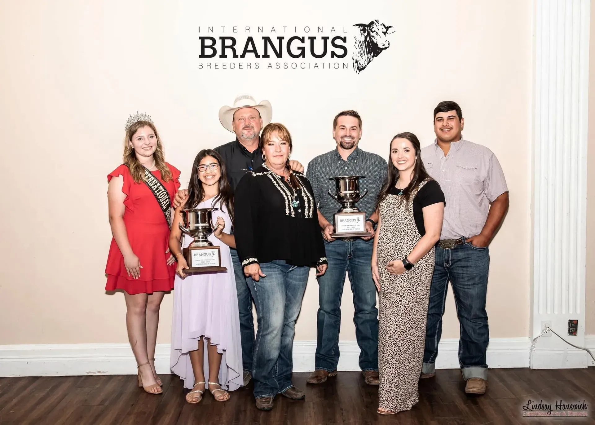 A group of people standing next to each other holding trophies. A group of people standing next to each other holding trophies.