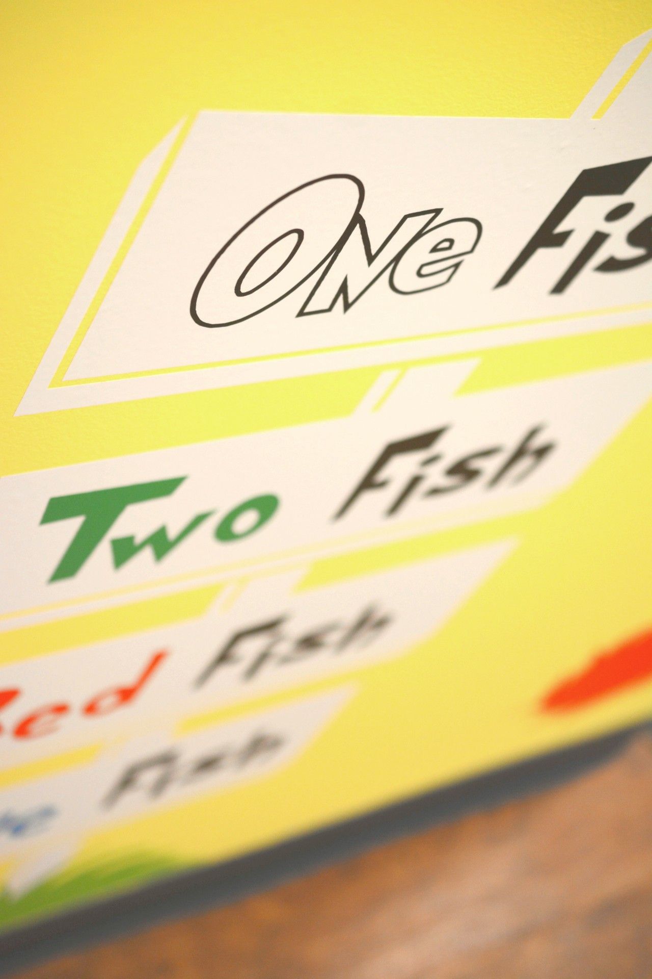 Yellow menu sign with stylized fish names, including “One Fish” and “Two Fish”