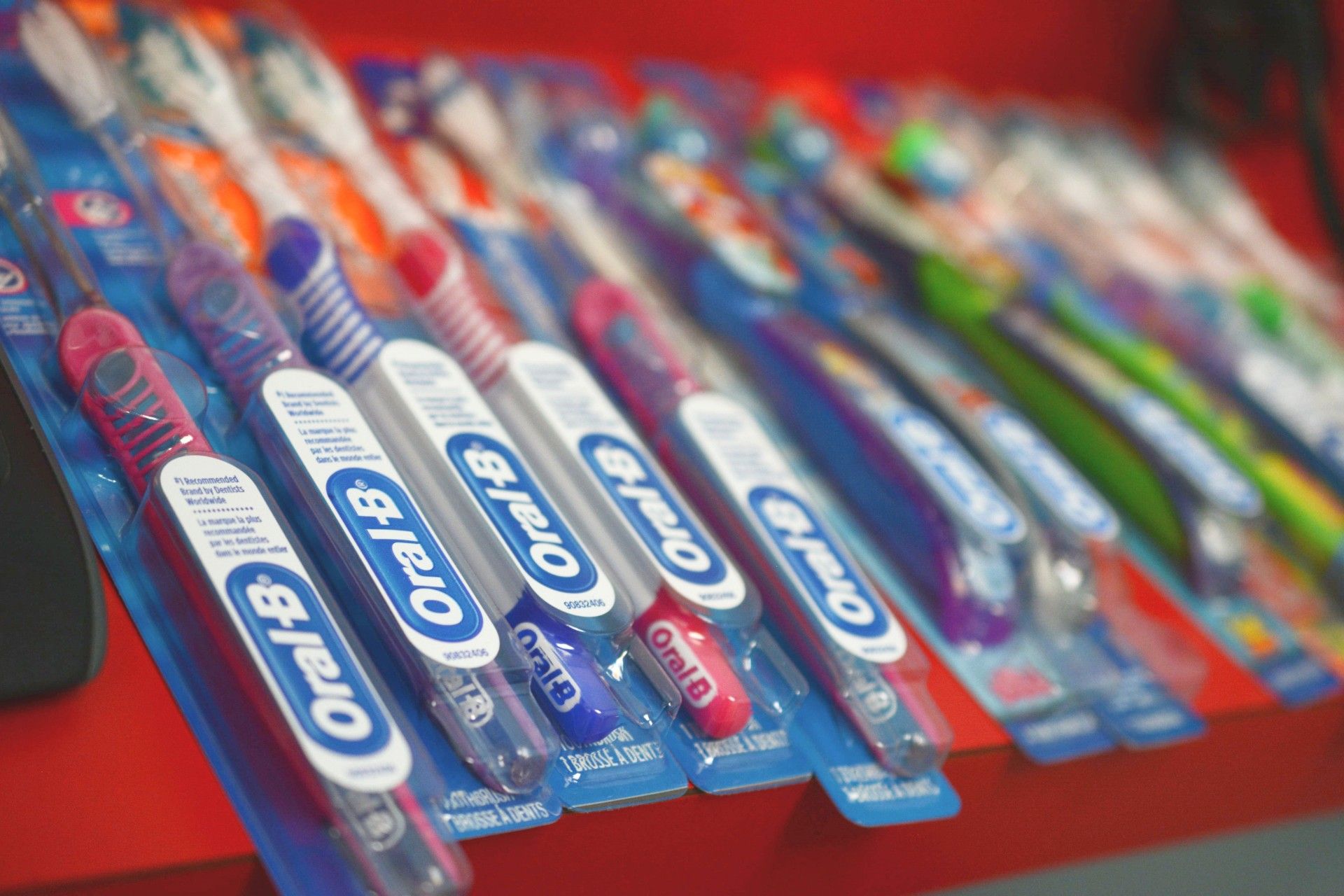 Assorted Orbit gum packs displayed on a red shelf in a store.