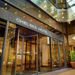 Chelsea Hotel entrance with glass doors and warm lobby lighting at night