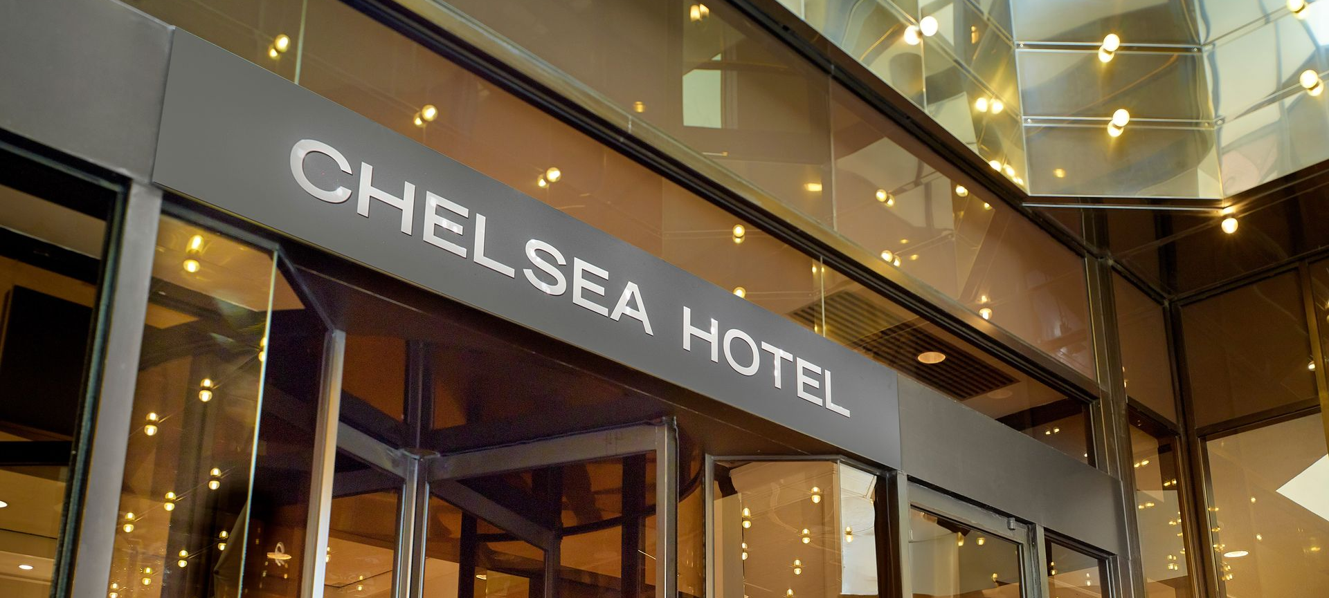 Chelsea Hotel entrance with glass doors and warm lobby lighting at night