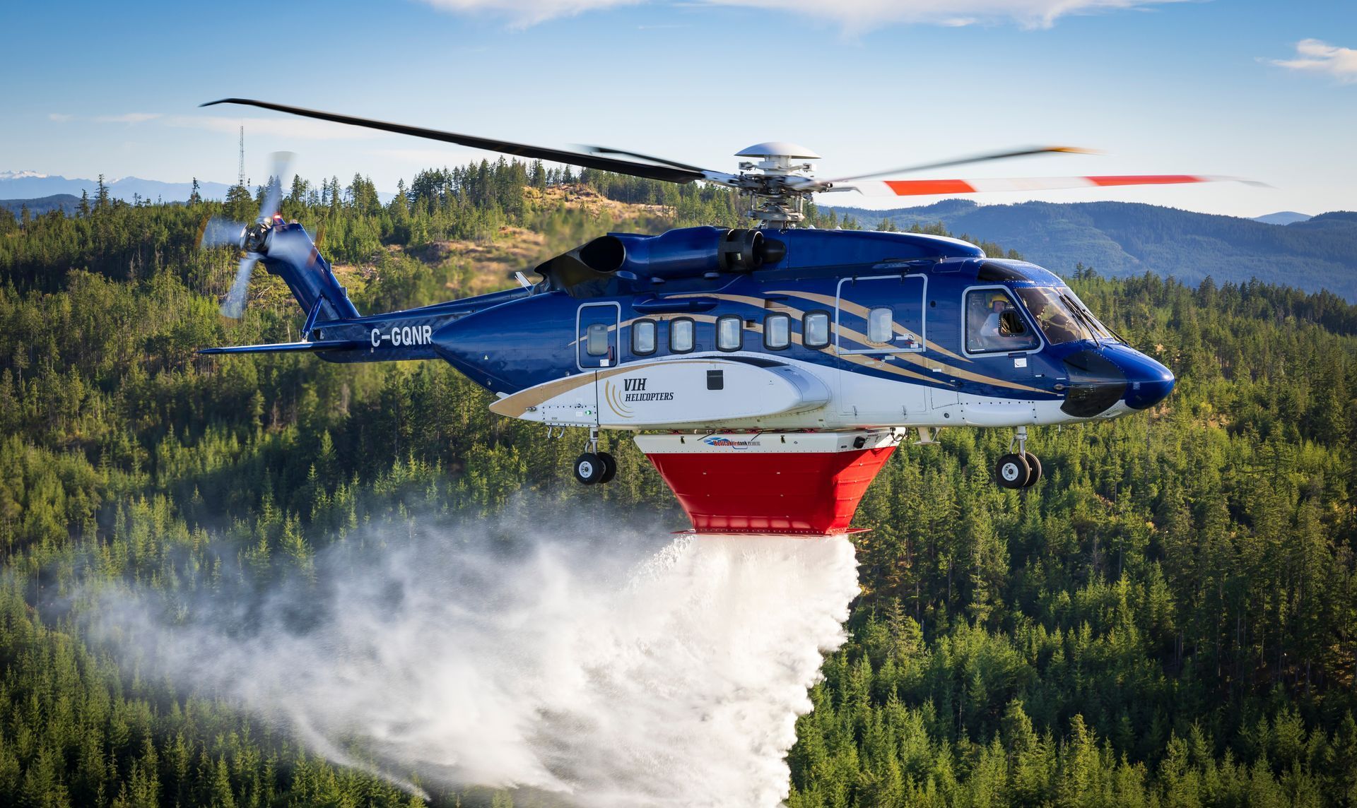 blue helicopter with helitak equipment in the air
