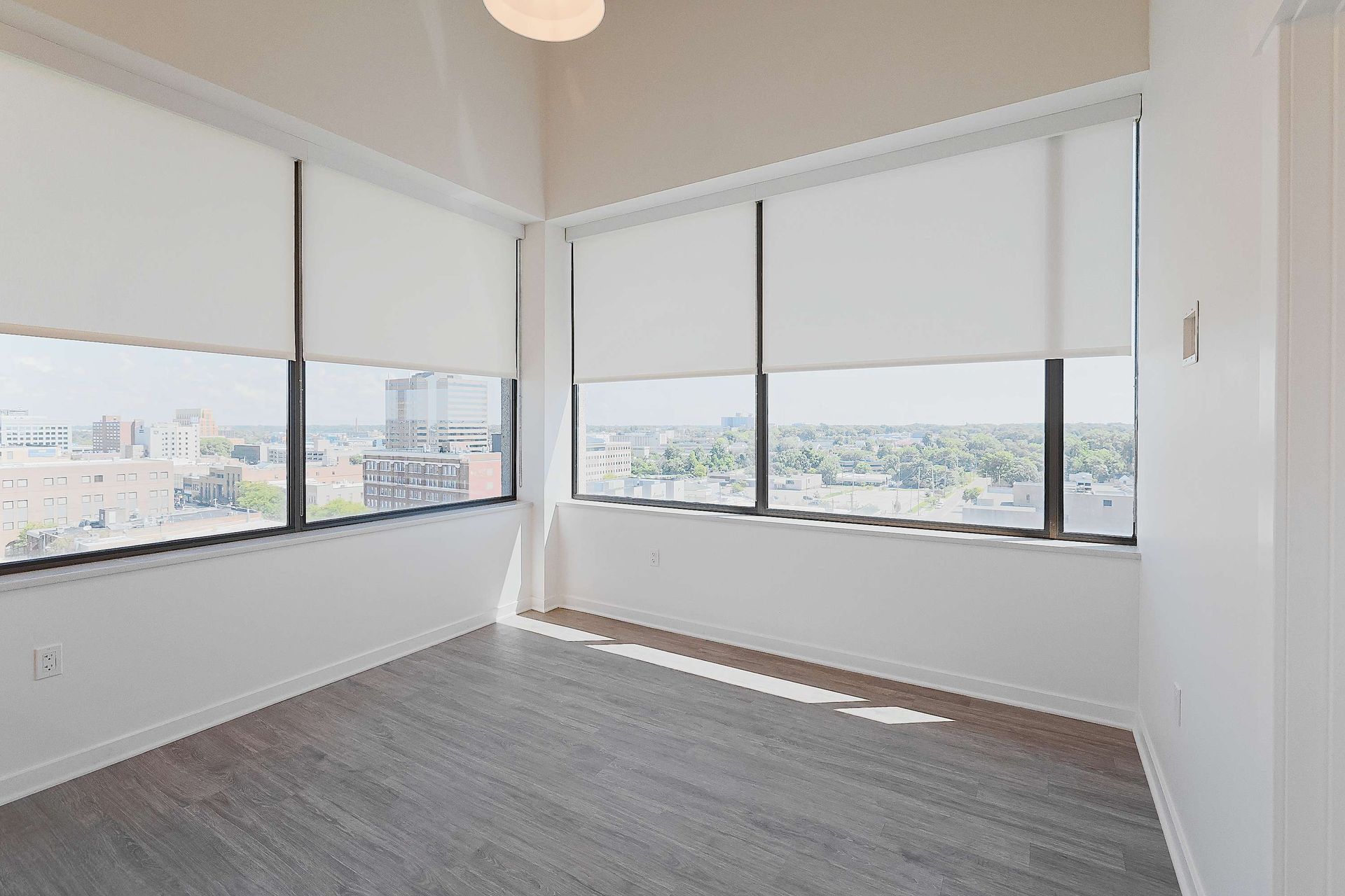 An empty room with a lot of windows and blinds.