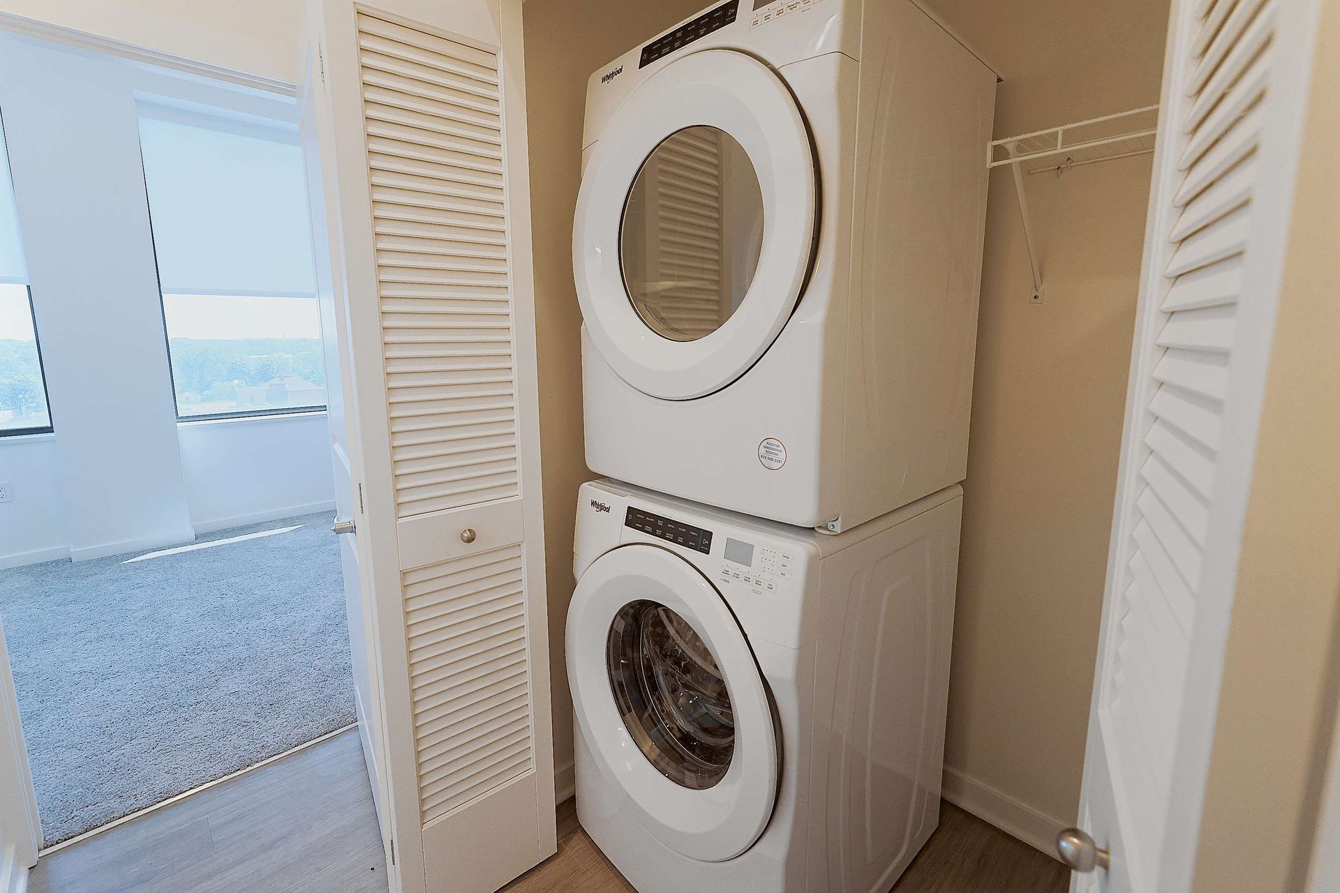 A washer and dryer are stacked on top of each other in a laundry room.