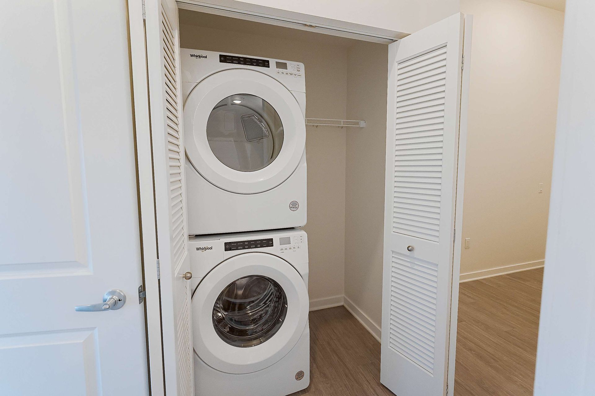 A washer and dryer are stacked on top of each other in a closet.