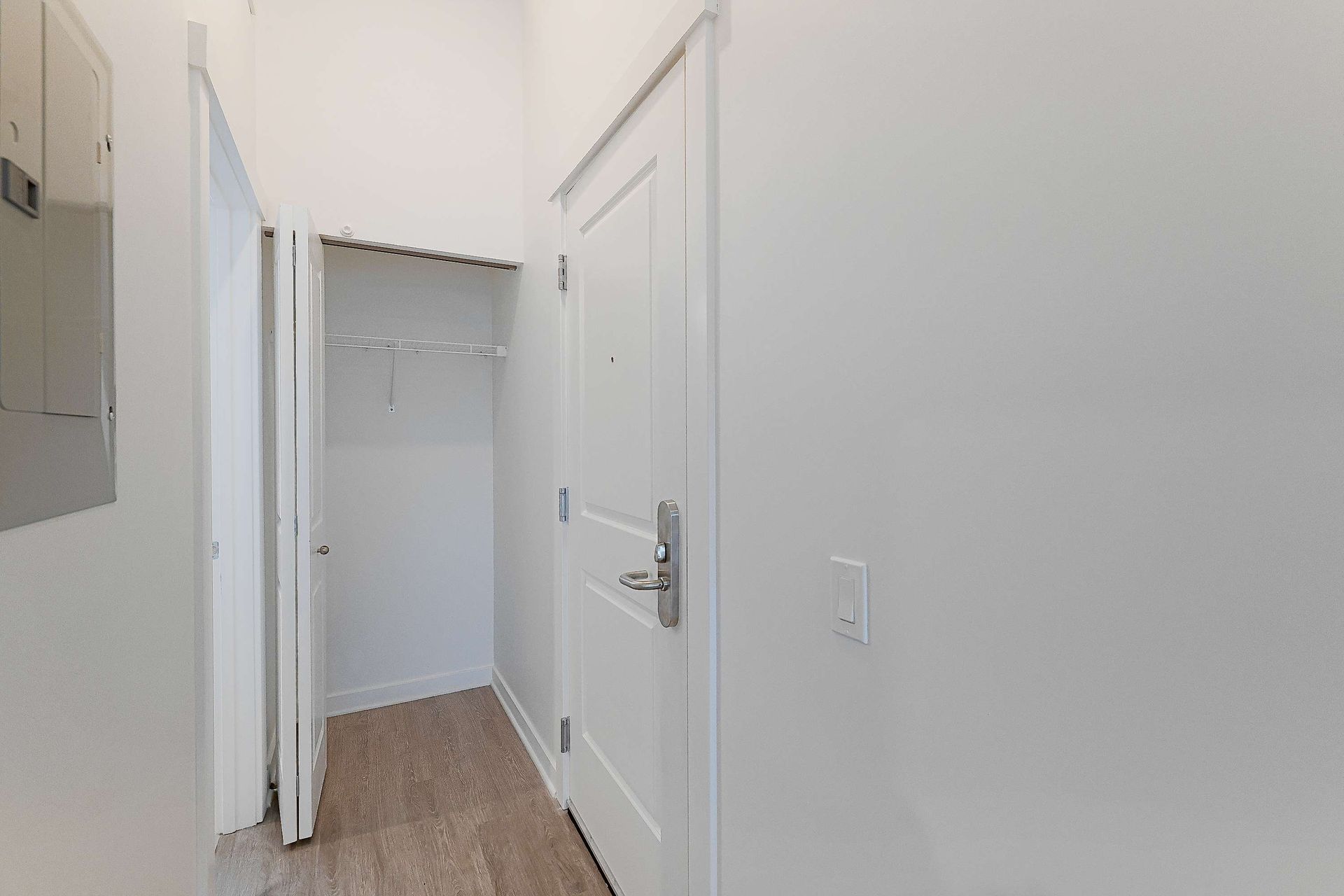 A hallway with a closet and a door in a house.