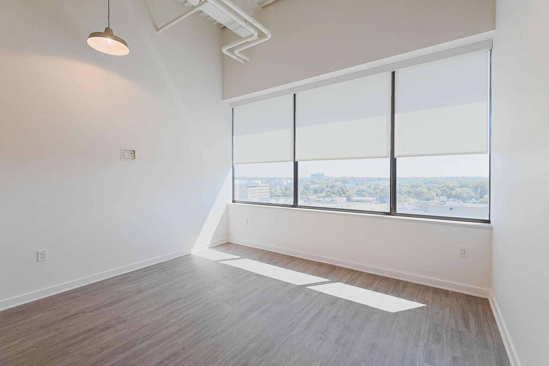 An empty room with a lot of windows and blinds.