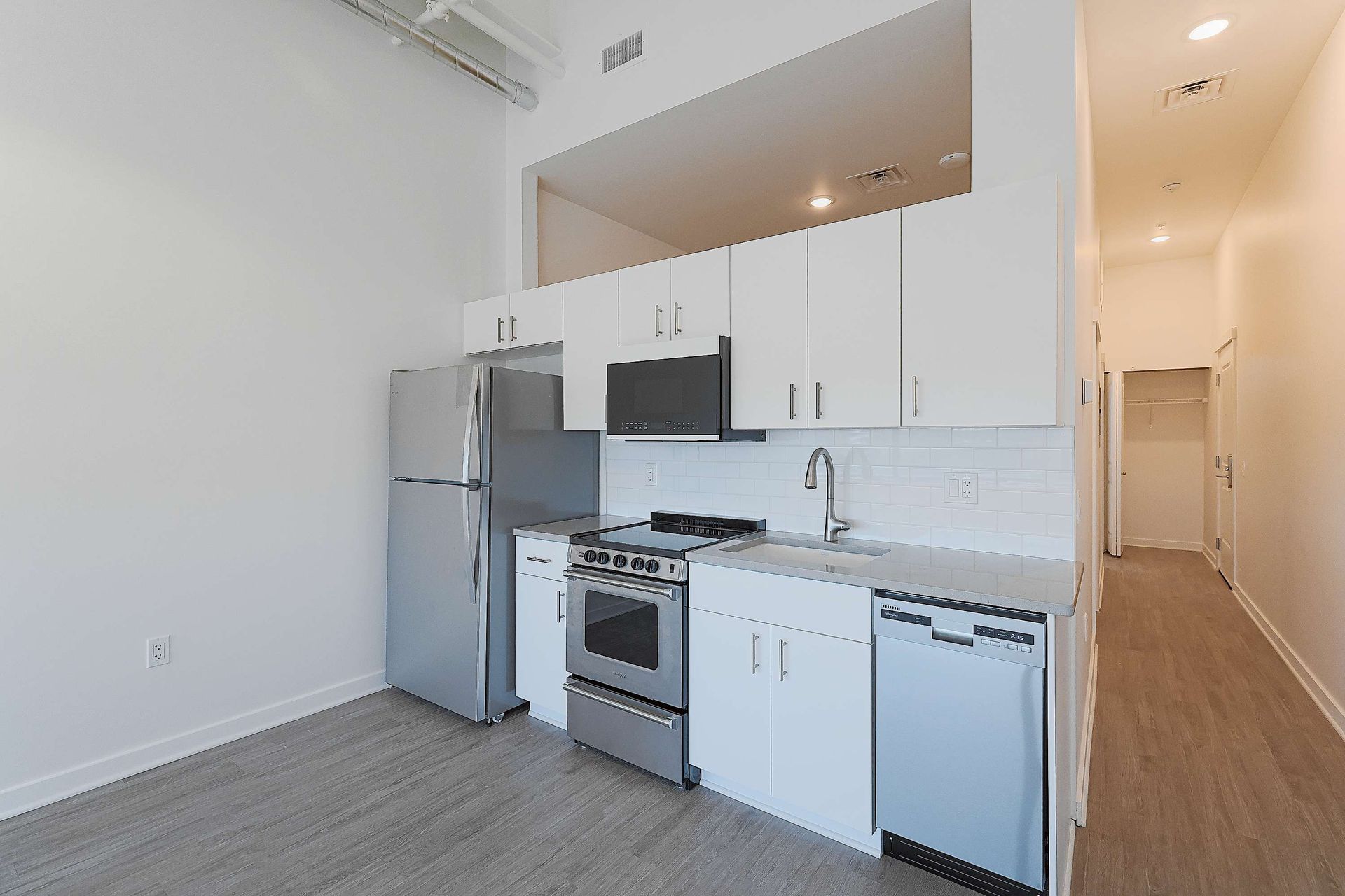 A kitchen with white cabinets and stainless steel appliances