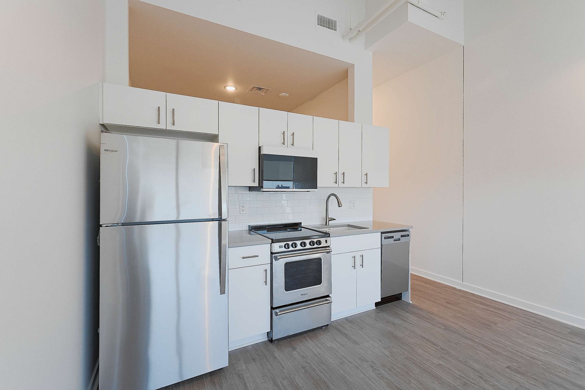 A kitchen with stainless steel appliances and white cabinets