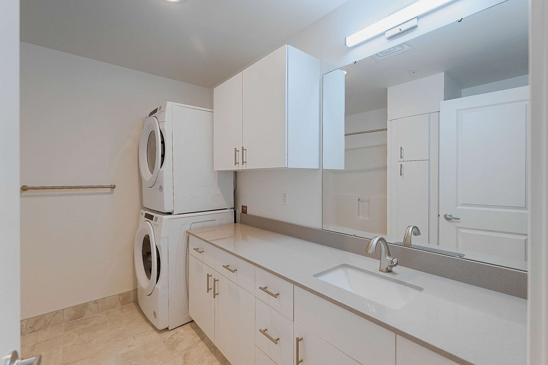 A bathroom with a washer and dryer stacked on top of each other.