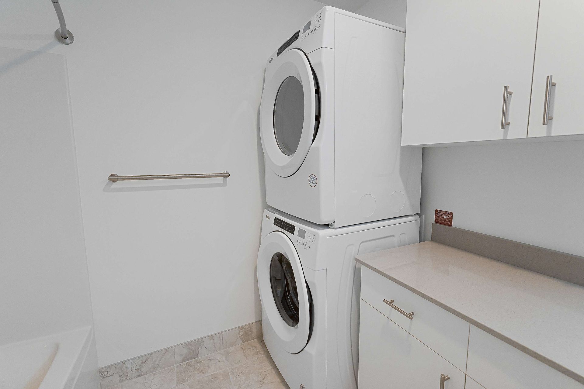 A laundry room with a washer and dryer stacked on top of each other.