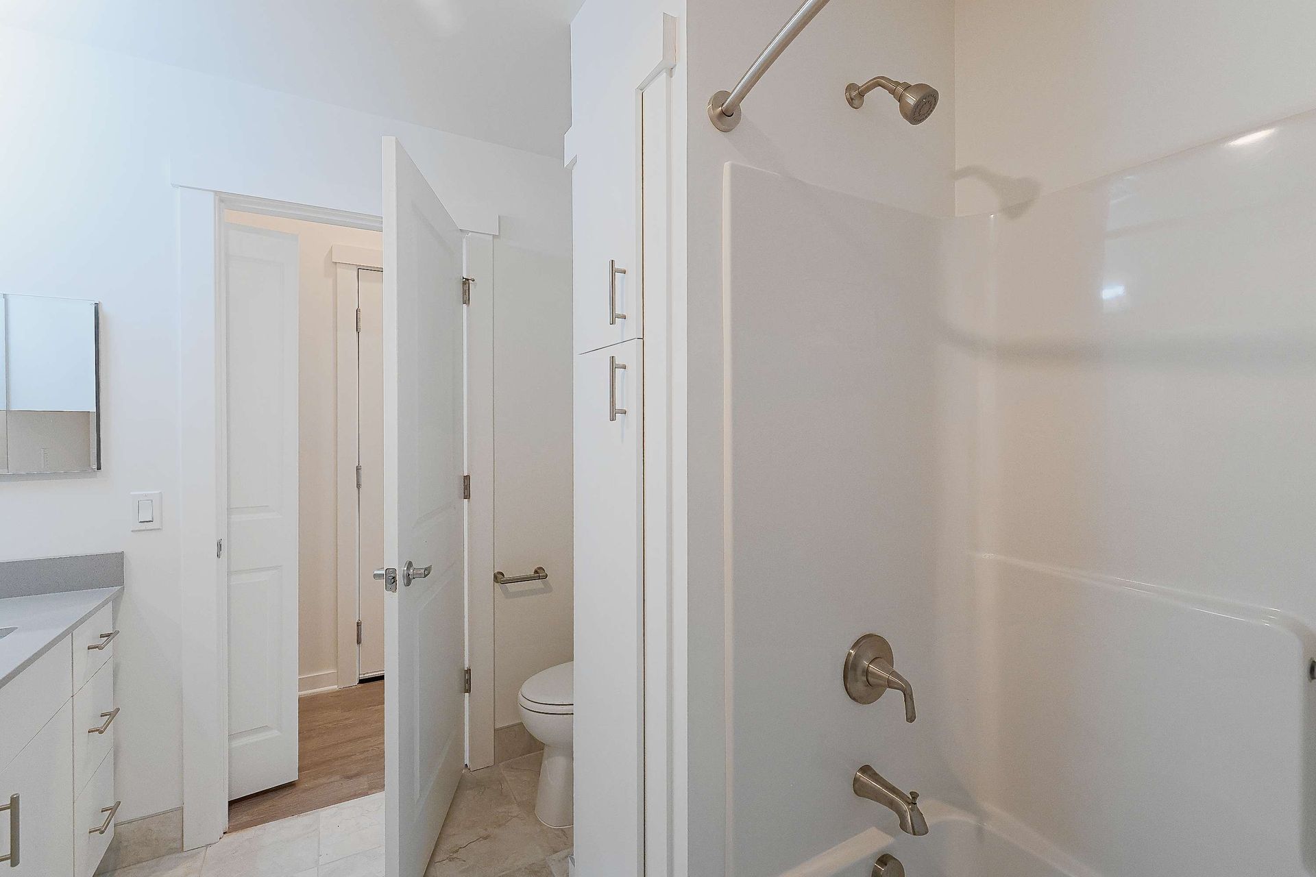 A bathroom with a tub , toilet , sink and shower.