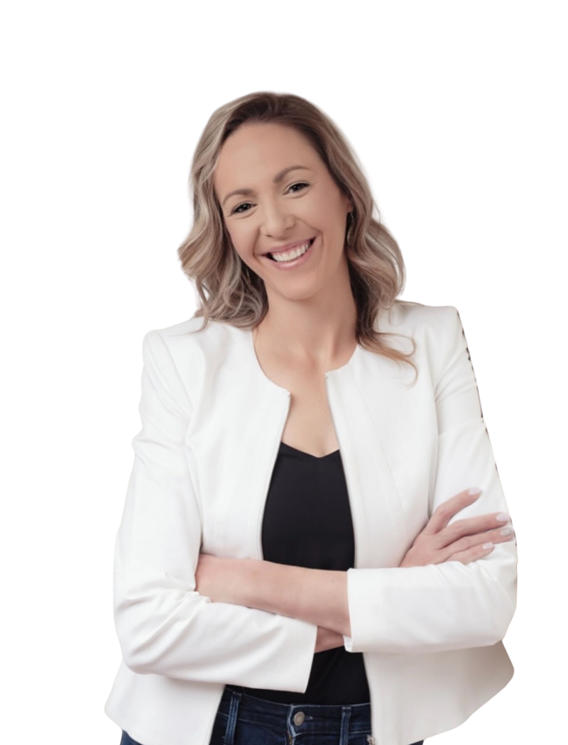 Woman with blonde hair smiles, wearing a white blazer over a black top, arms crossed.