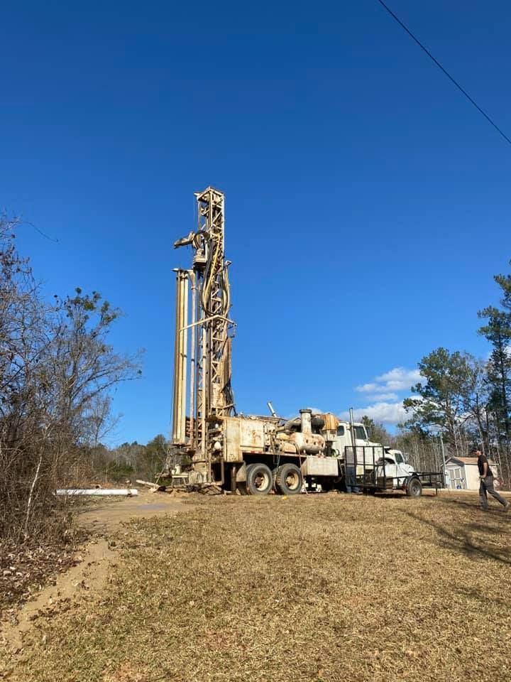 Well drilling rig in a field on a sunny day.