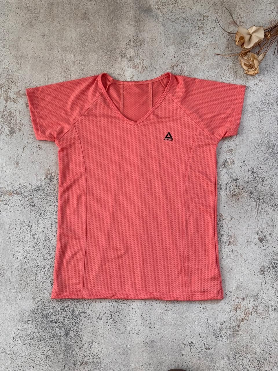 Cuatro camisetas de colores dobladas —negra, morada, amarilla y coral— y una camiseta coral