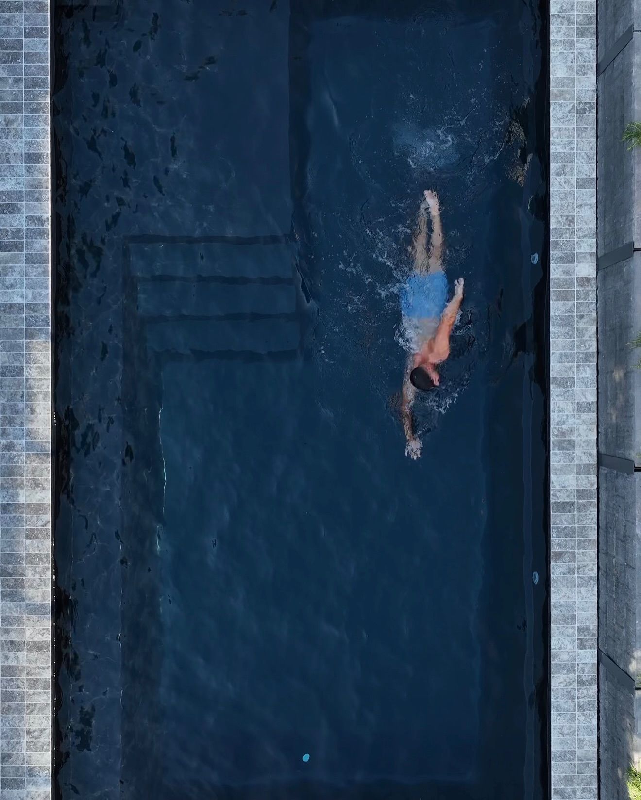 A Person in Blue Swim in a Rectangular Dark-tiled Swimming Pool — Billabong Pool Co in Smeaton Grange, NSW