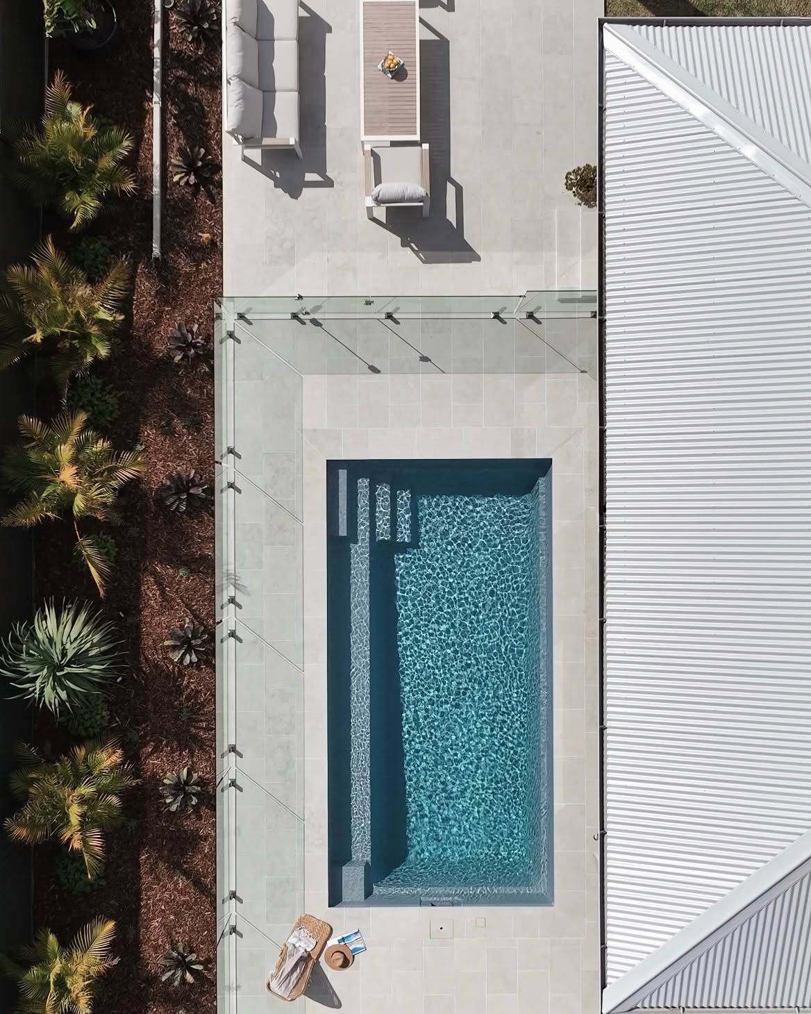 Overhead View of a Rectangular Pool Beside Lounge Chairs and a White-roofed Building — Billabong Pool Co in Wollongong, NSW