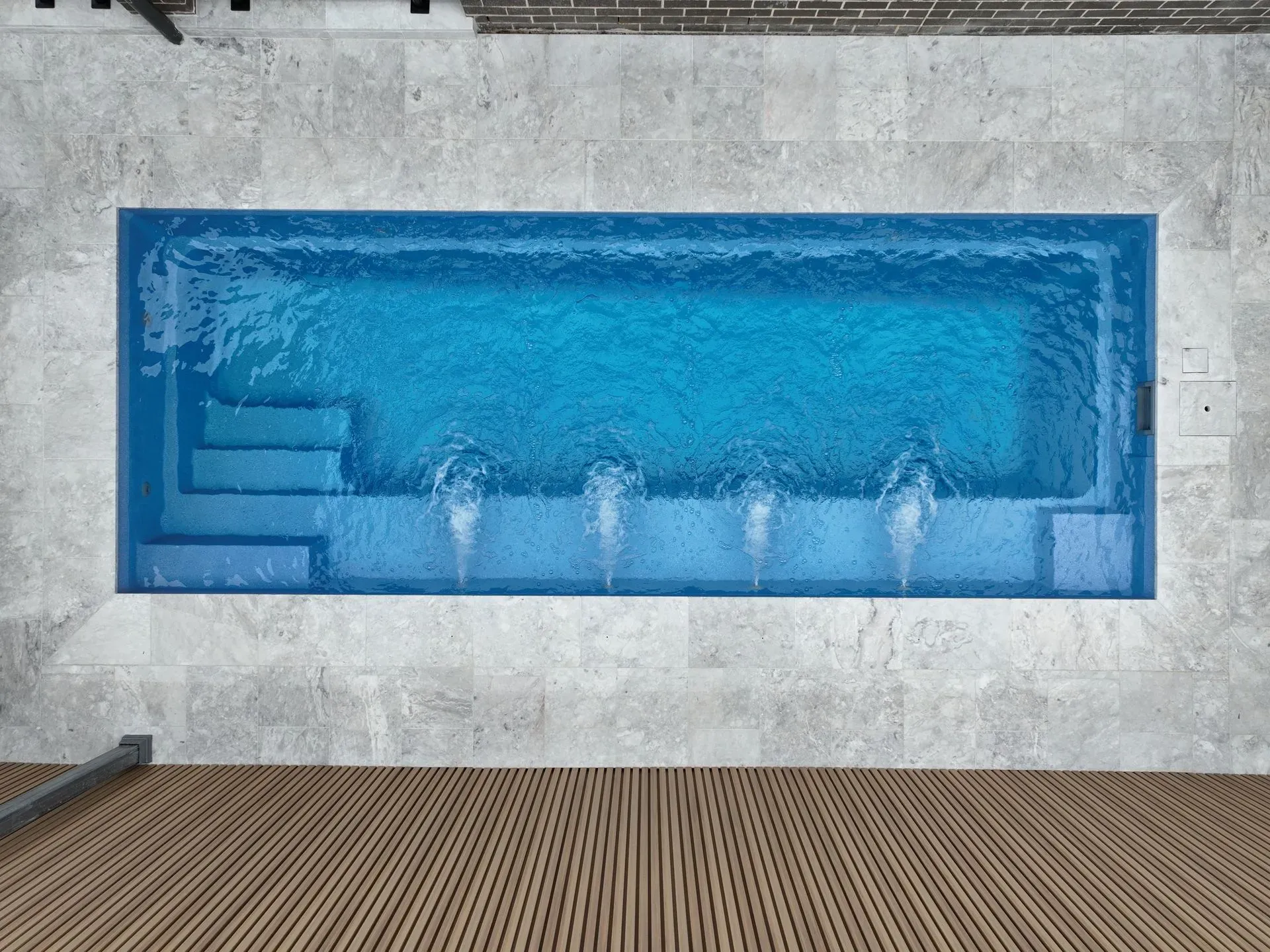 Blue Rectangular Swimming Pool Set Into a Stone Wall — Billabong Pool Co in Smeaton Grange, NSW