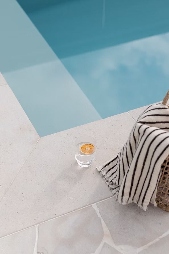 A Person Is Sitting on A Chair Next to A Swimming Pool — Billabong Pool Co in Smeaton Grange, NSW