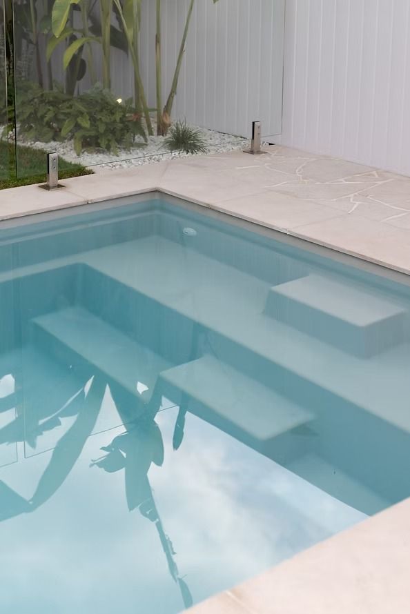 A Large Swimming Pool with Stairs Leading up To It — Billabong Pool Co in Smeaton Grange, NSW