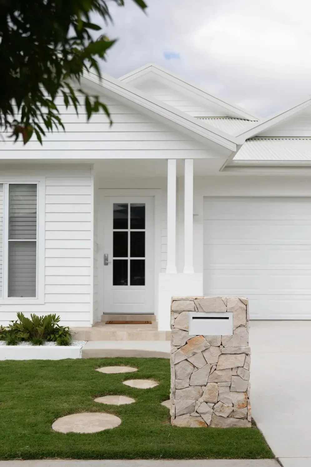 White House Exterior With Front Door, Garage, and Stone Mailbox — Billabong Pool Co in Smeaton Grange, NSW