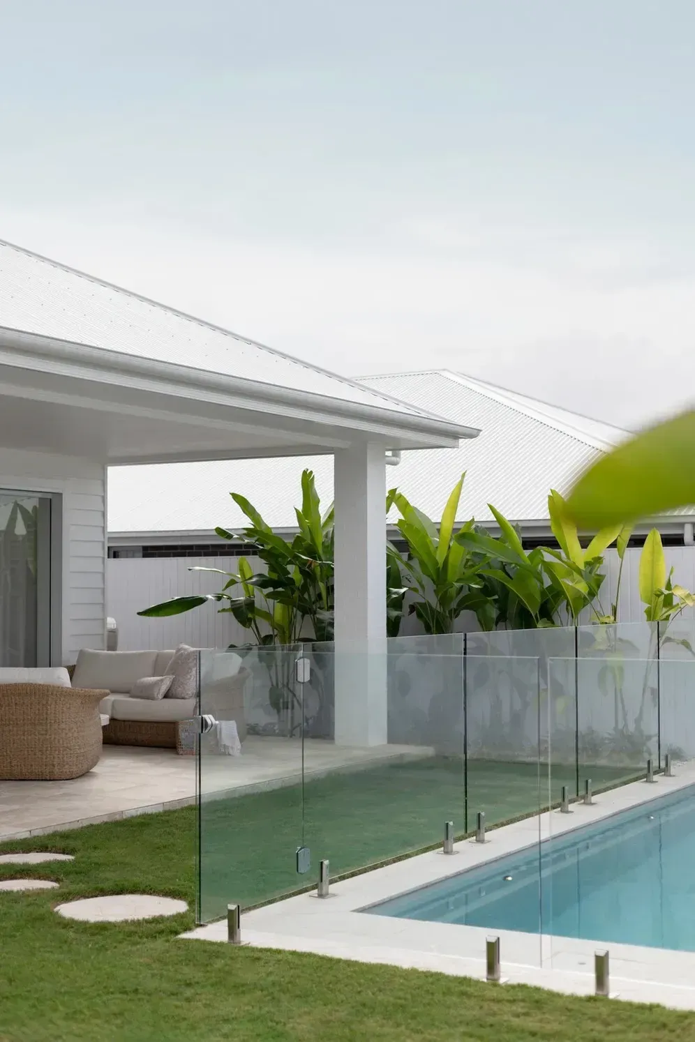 Modern Patio With Glass Pool Fence, White Lounge Area — Billabong Pool Co in Smeaton Grange, NSW