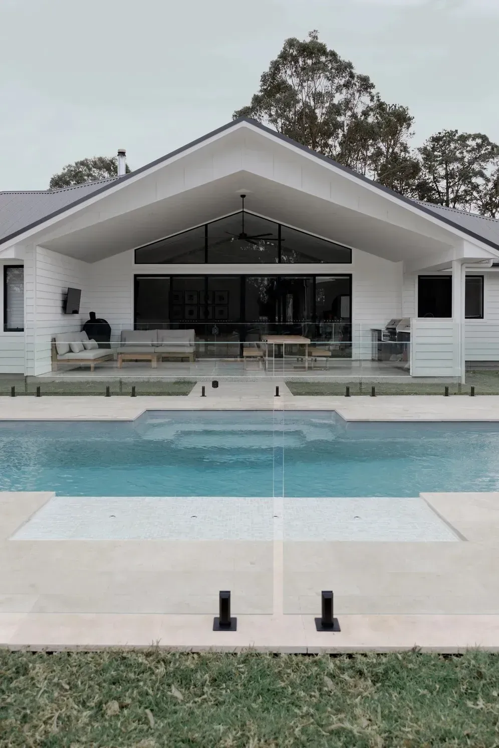 Modern White House With a Central Pool and Patio, Viewed From the Lawn — Billabong Pool Co in Smeaton Grange, NSW