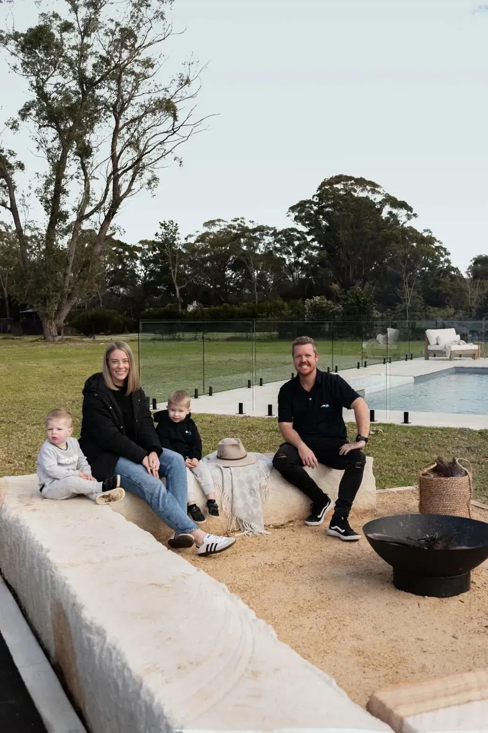 Four People Sit on a Sandy Patio by a Pool — Billabong Pool Co in Smeaton Grange, NSW