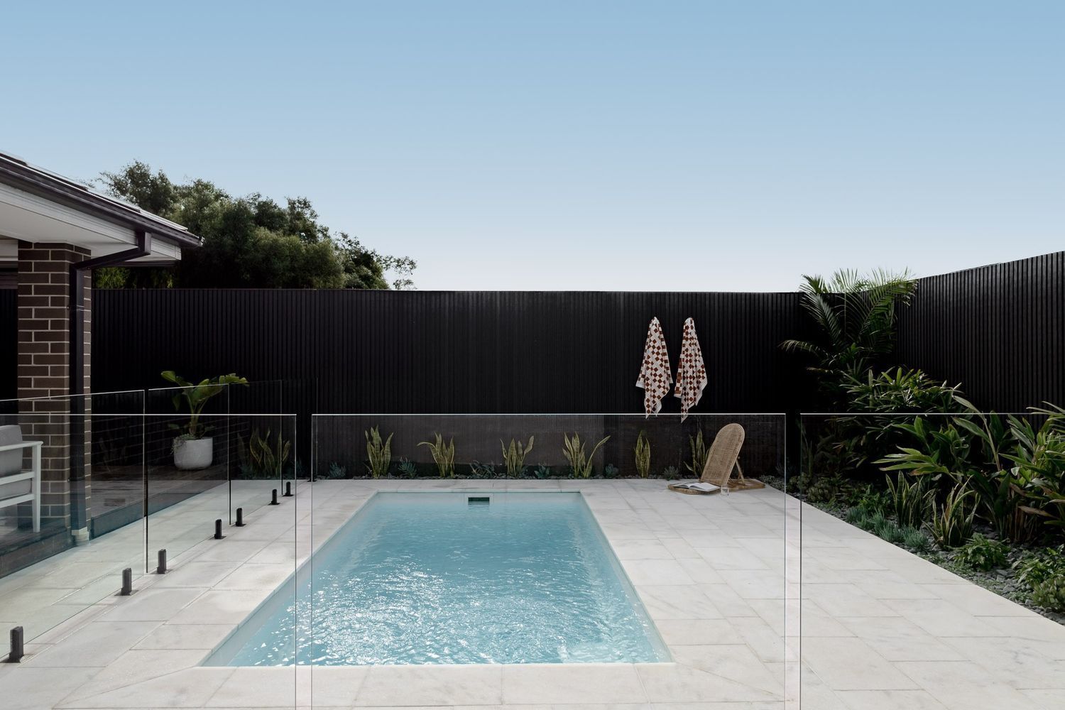 Modern Backyard With a Rectangular Pool, Pale Stone Patio — Billabong Pool Co in Smeaton Grange, NSW