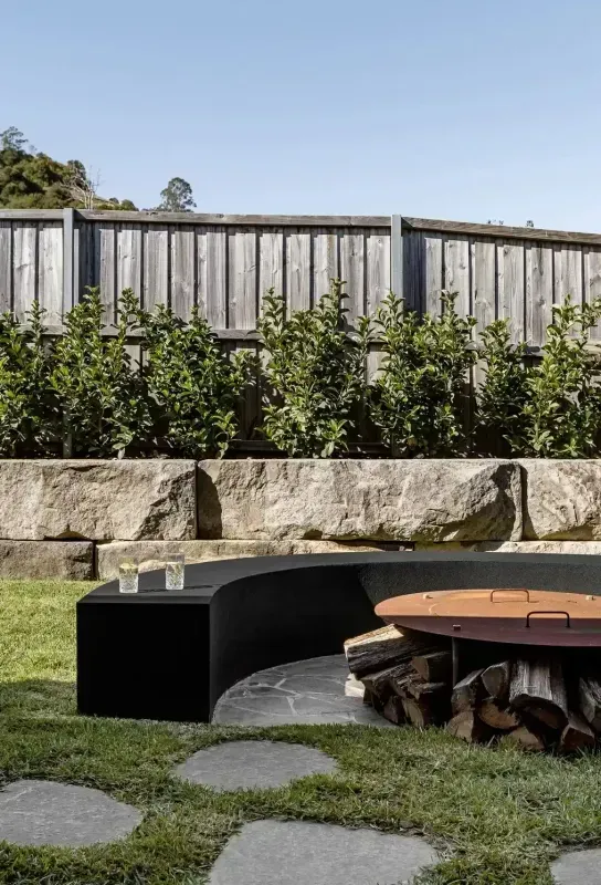 Modern Backyard With Black Bench, Stone Border, Circular Fire Pit — Billabong Pool Co in Smeaton Grange, NSW