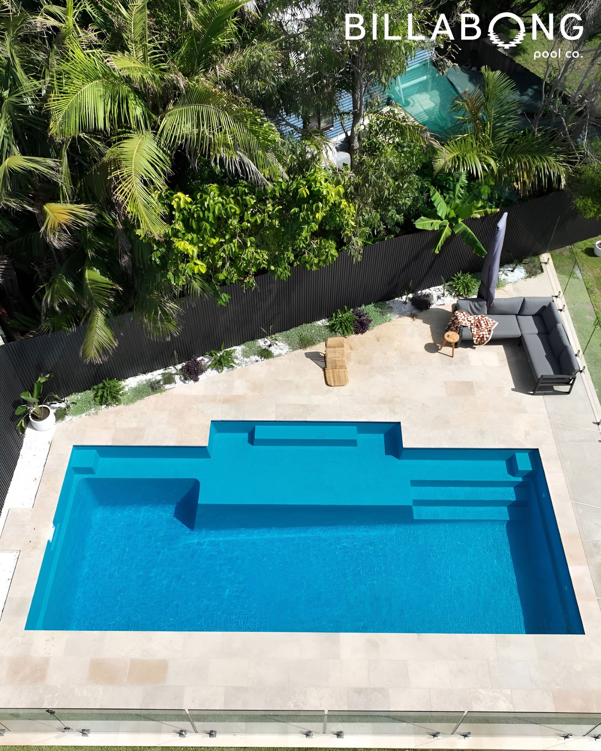 Blue Pool Surrounded by Concrete, Plants, and Lounge Area — Billabong Pool Co in Smeaton Grange, NSW