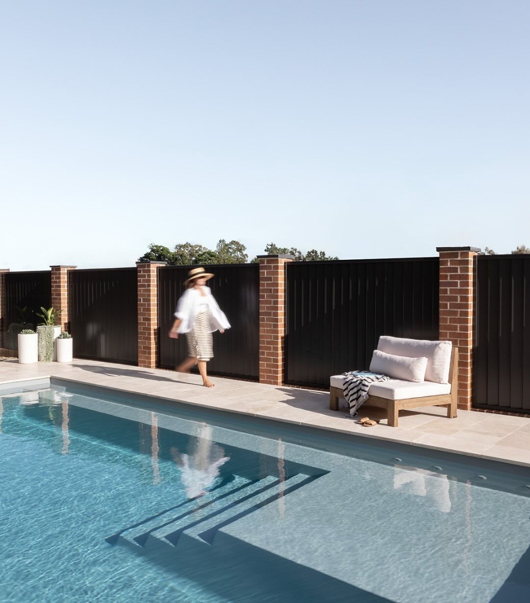 A Woman Is Walking Next To A Pool — Billabong Pool Co in Camden, NSW