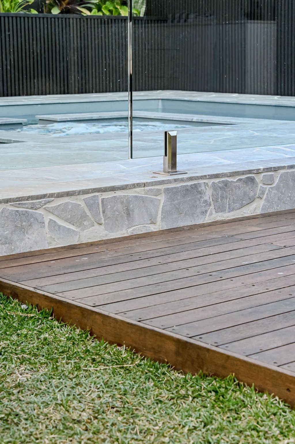 Empty Outdoor Pool Beside a Wooden Deck and Grass — Billabong Pool Co in Smeaton Grange, NSW