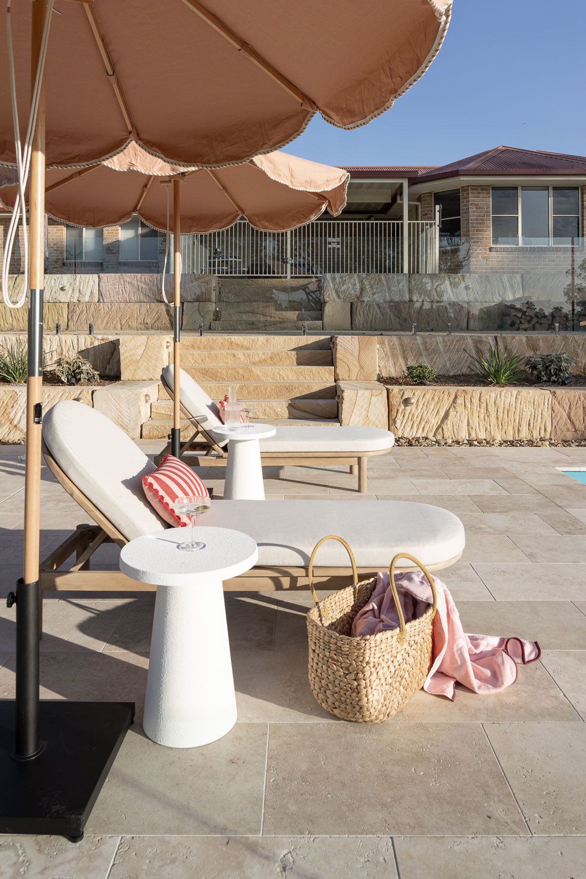 Patio Lounge Chairs Under a Tan Umbrella Beside a Woven Bag — Billabong Pool Co in Smeaton Grange, NSW