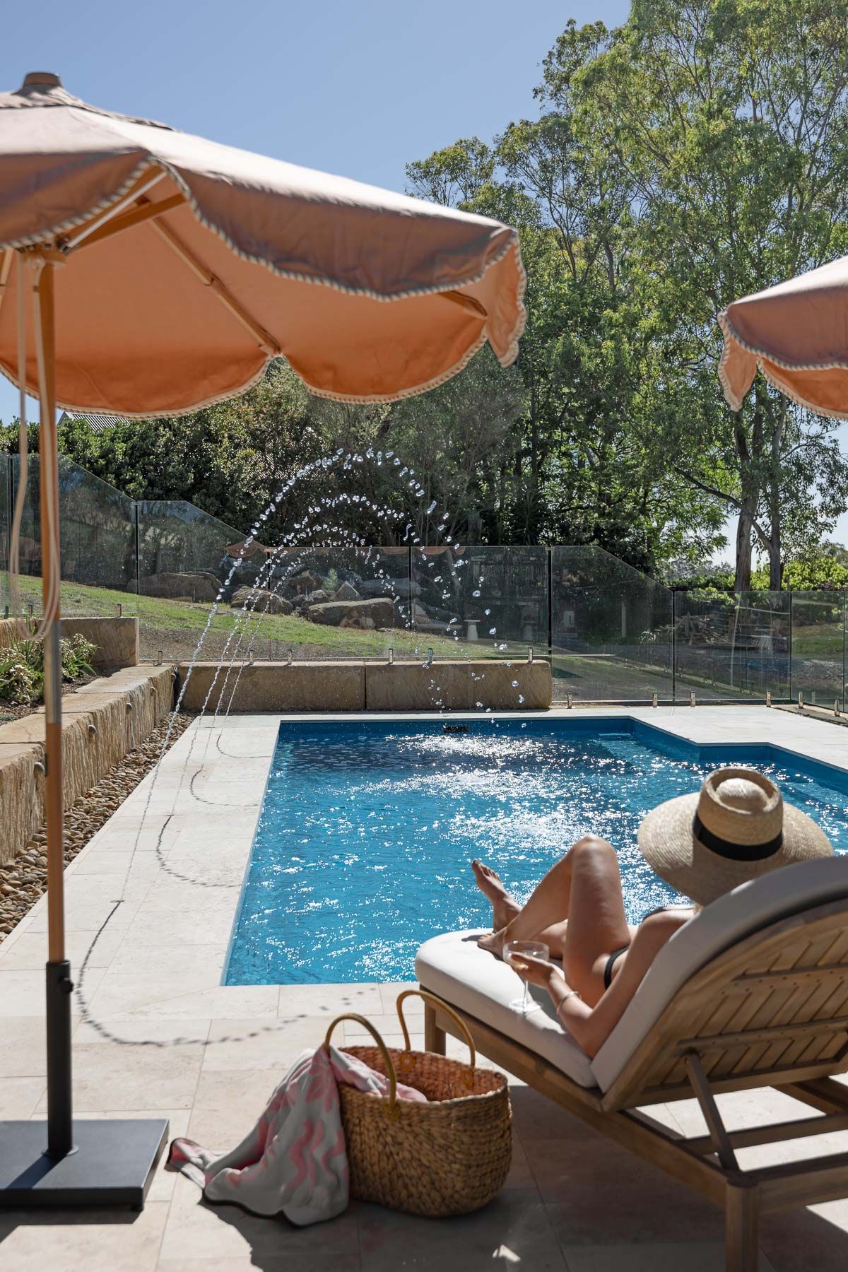 Poolside Lounge Chair Under Orange Umbrella — Billabong Pool Co in Smeaton Grange, NSW