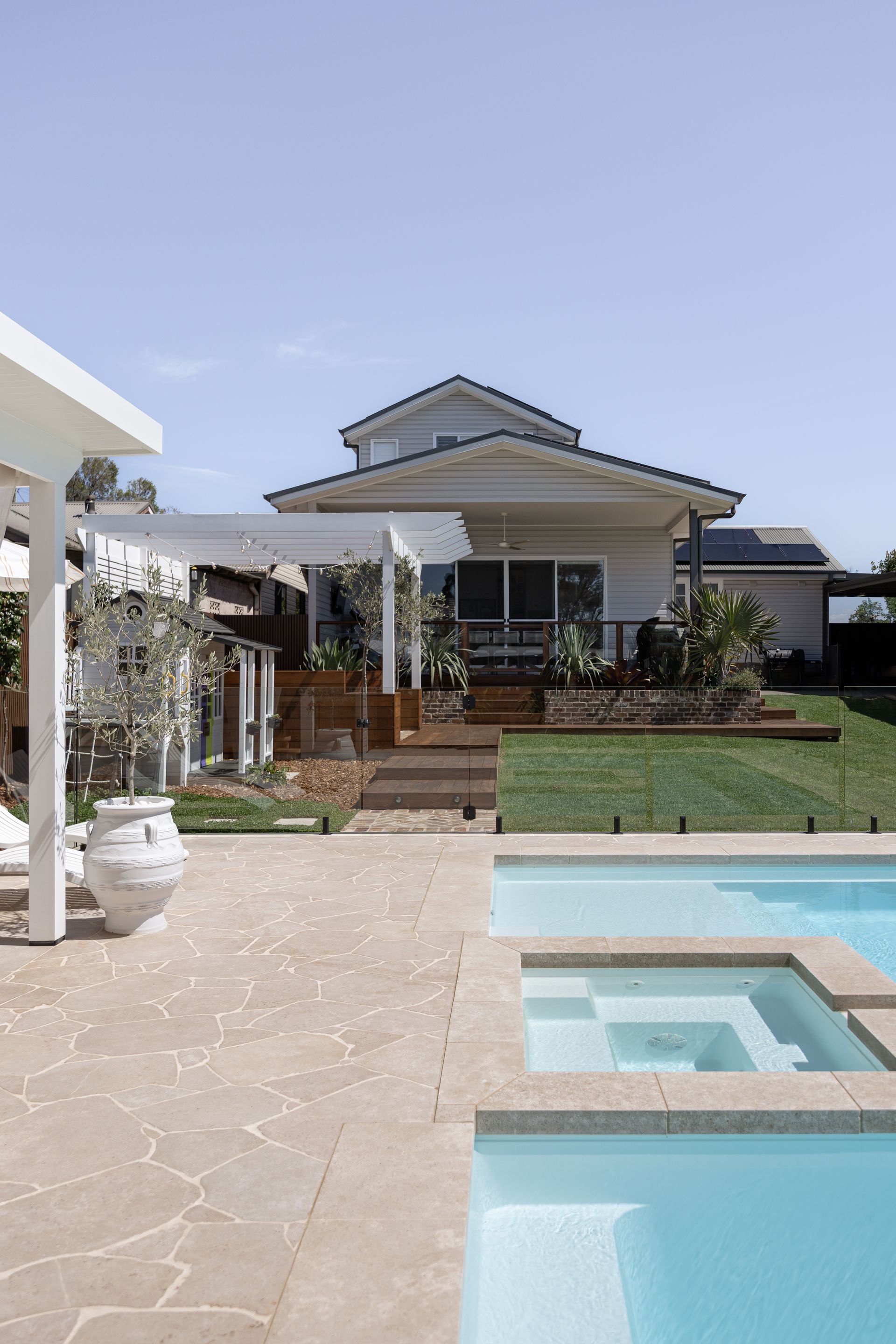 Modern House With Patio, Lawn, and Blue Swimming Pool Under a Clear Sky — Billabong Pool Co in Smeaton Grange, NSW