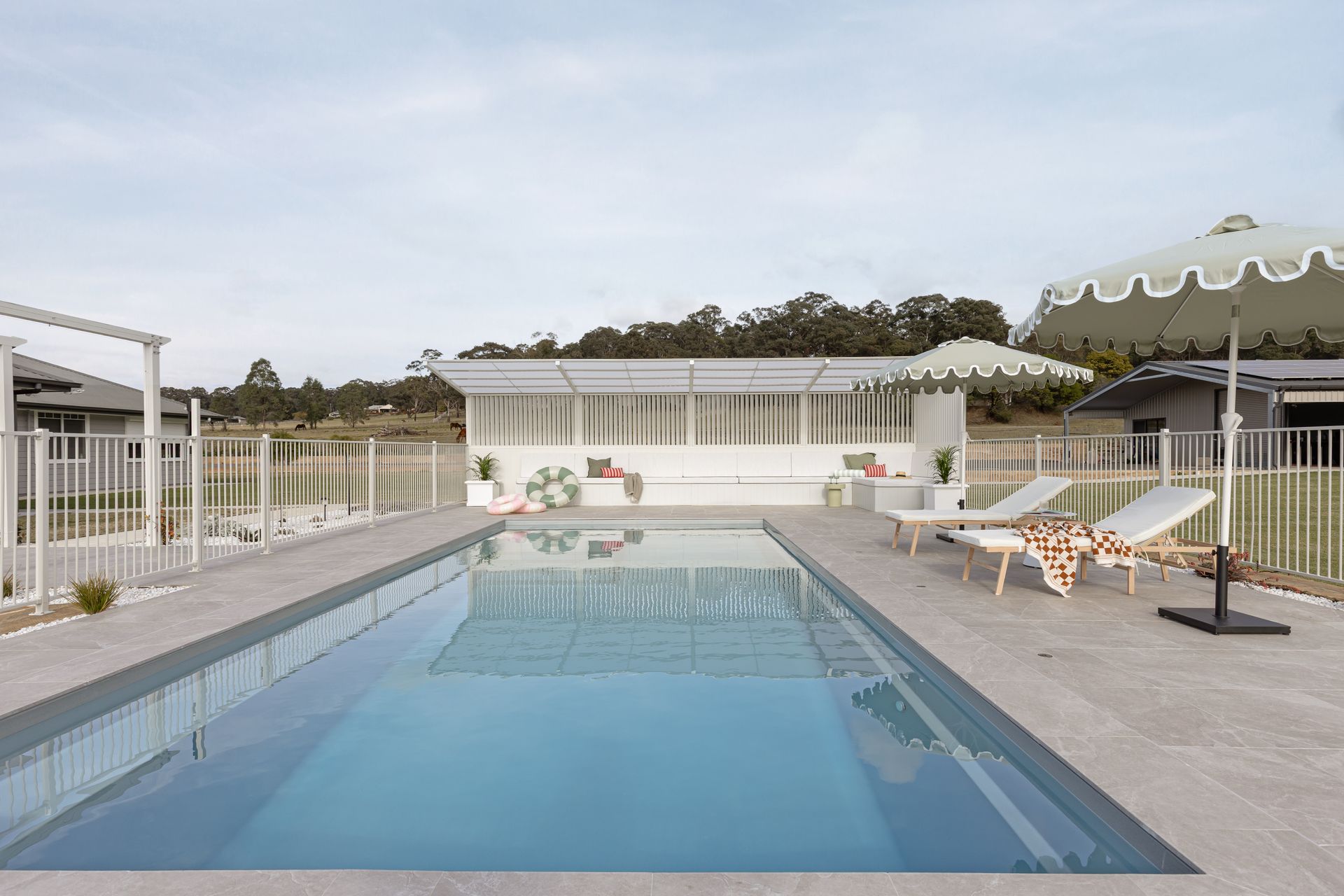 Outdoor Swimming Pool With Blue Water, White Fence — Billabong Pool Co in Smeaton Grange, NSW