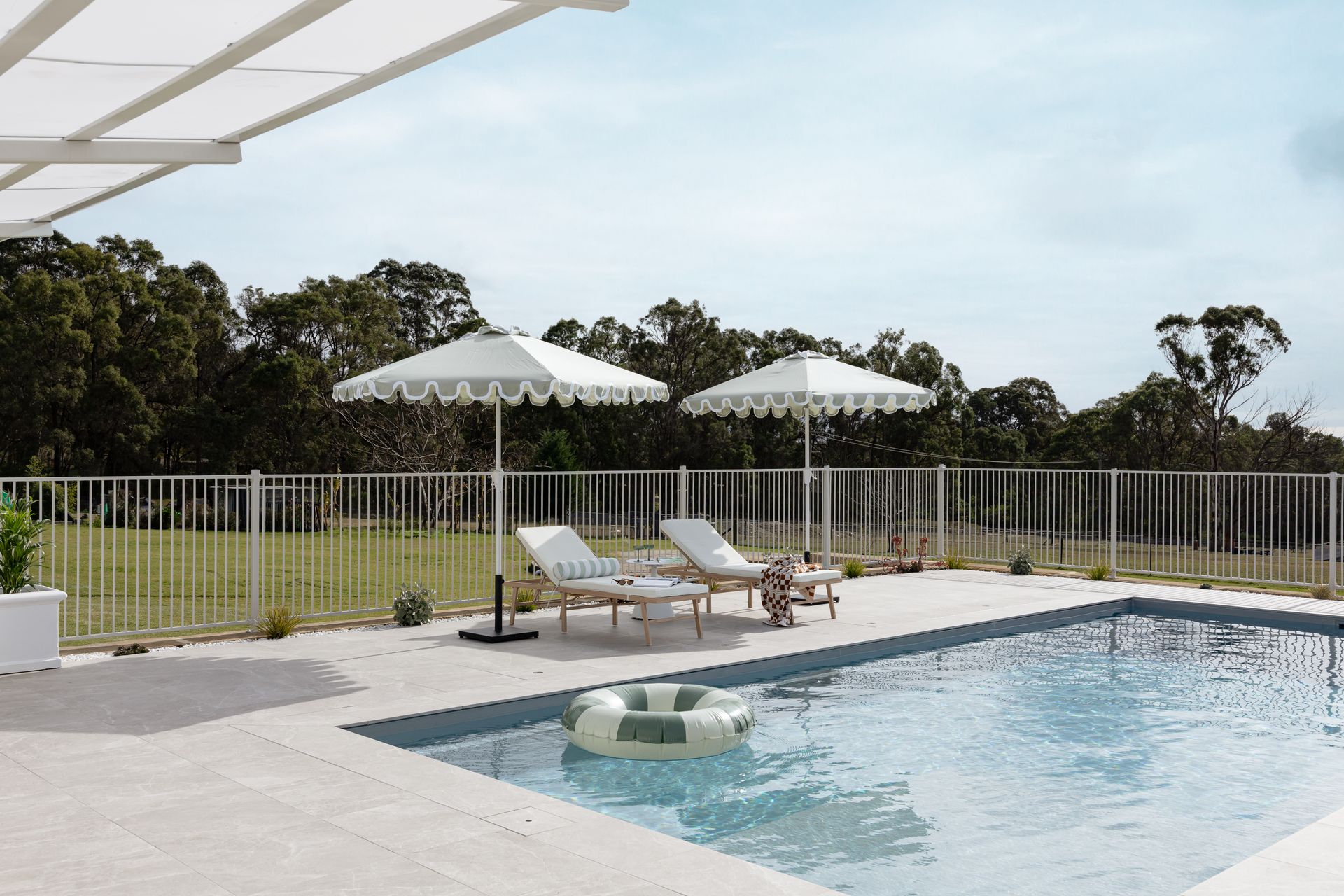 Backyard Pool With Lounge Chairs, White Umbrellas — Billabong Pool Co in Smeaton Grange, NSW
