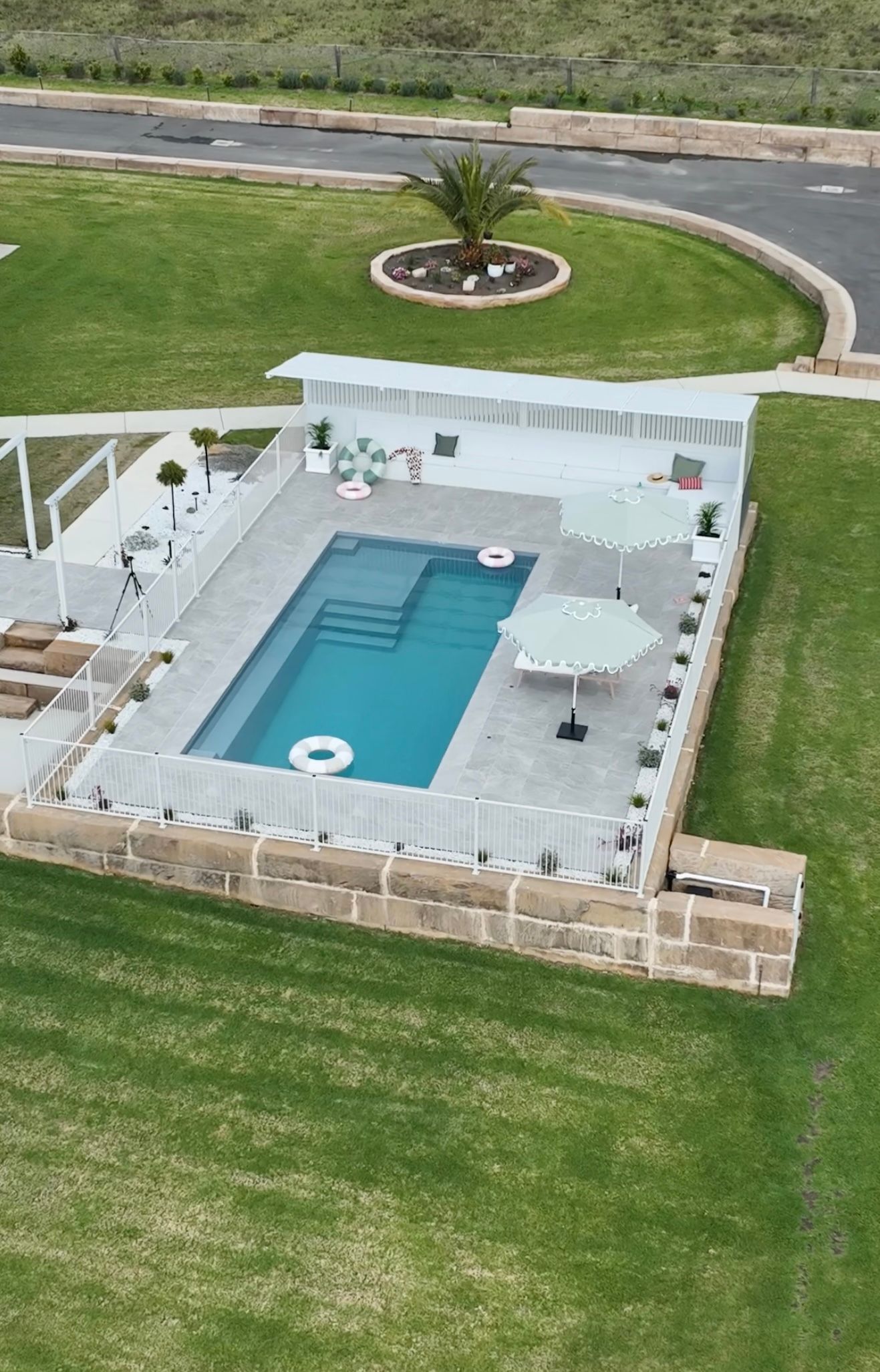 Backyard Pool With Light Blue Water, White Patio — Billabong Pool Co in Smeaton Grange, NSW