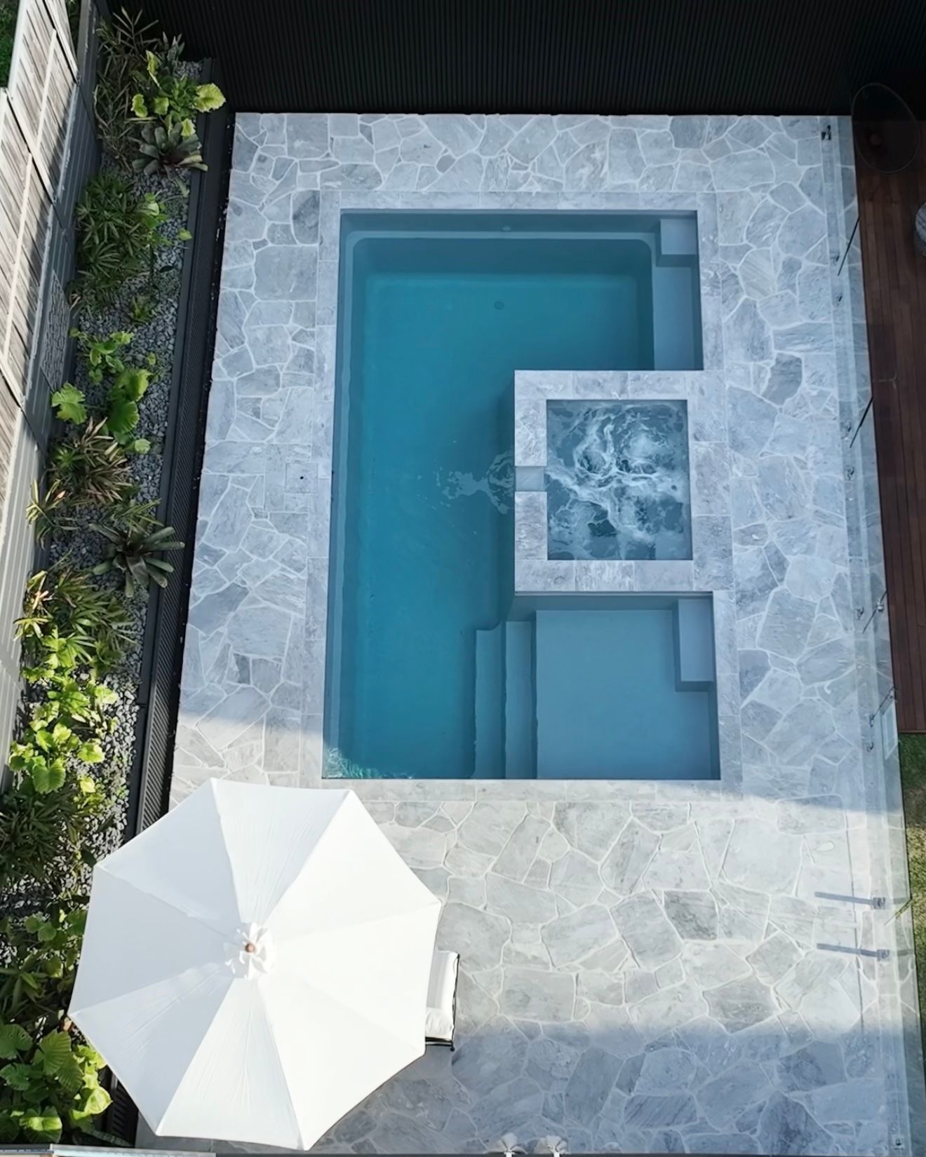 Top-down View of a Small Blue Pool With a Stone Deck and White Patio Umbrella — Billabong Pool Co in Smeaton Grange, NSW