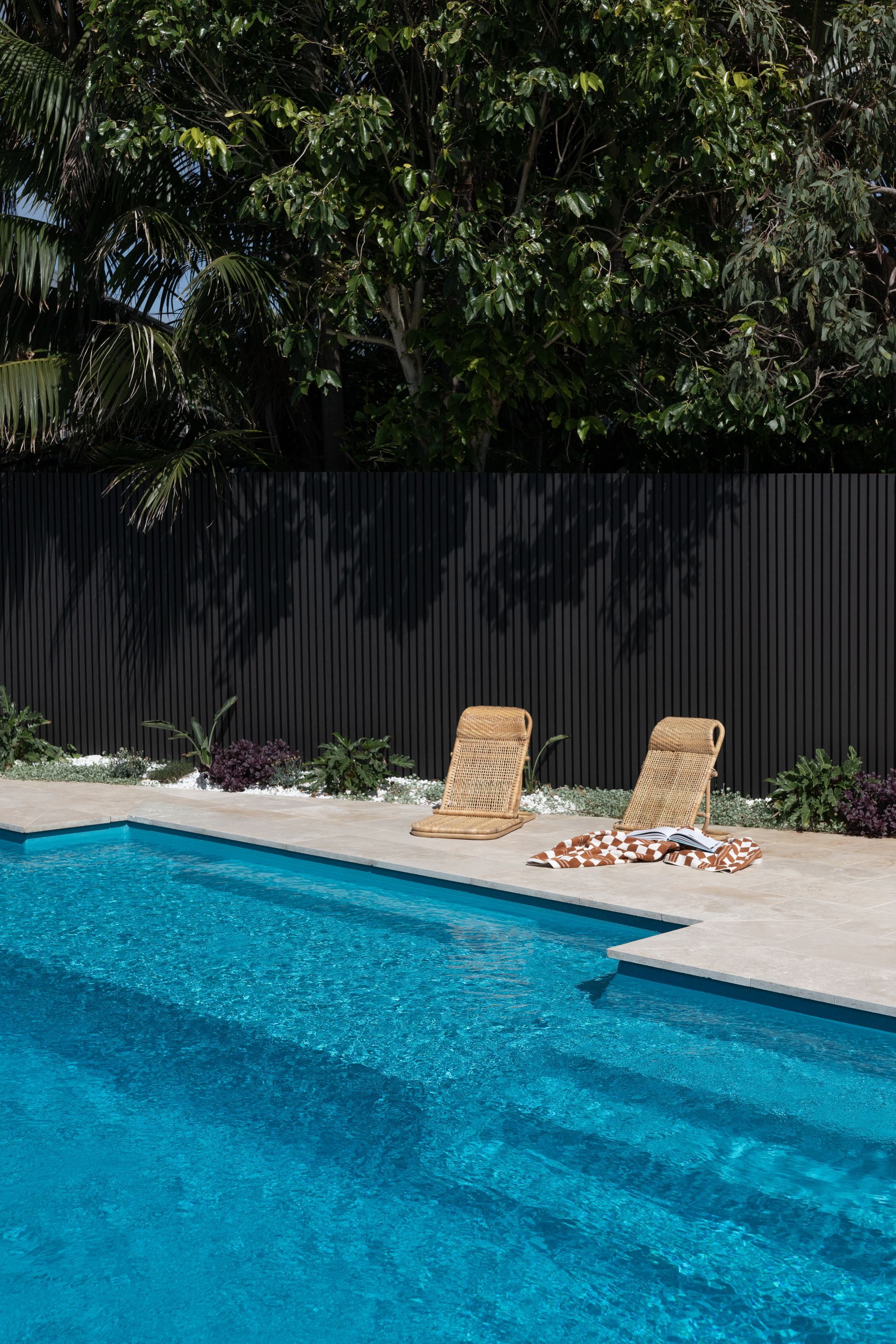 Backyard Swimming Pool With Two Lounge Chairs on a Sunlit Deck — Billabong Pool Co in Smeaton Grange, NSW