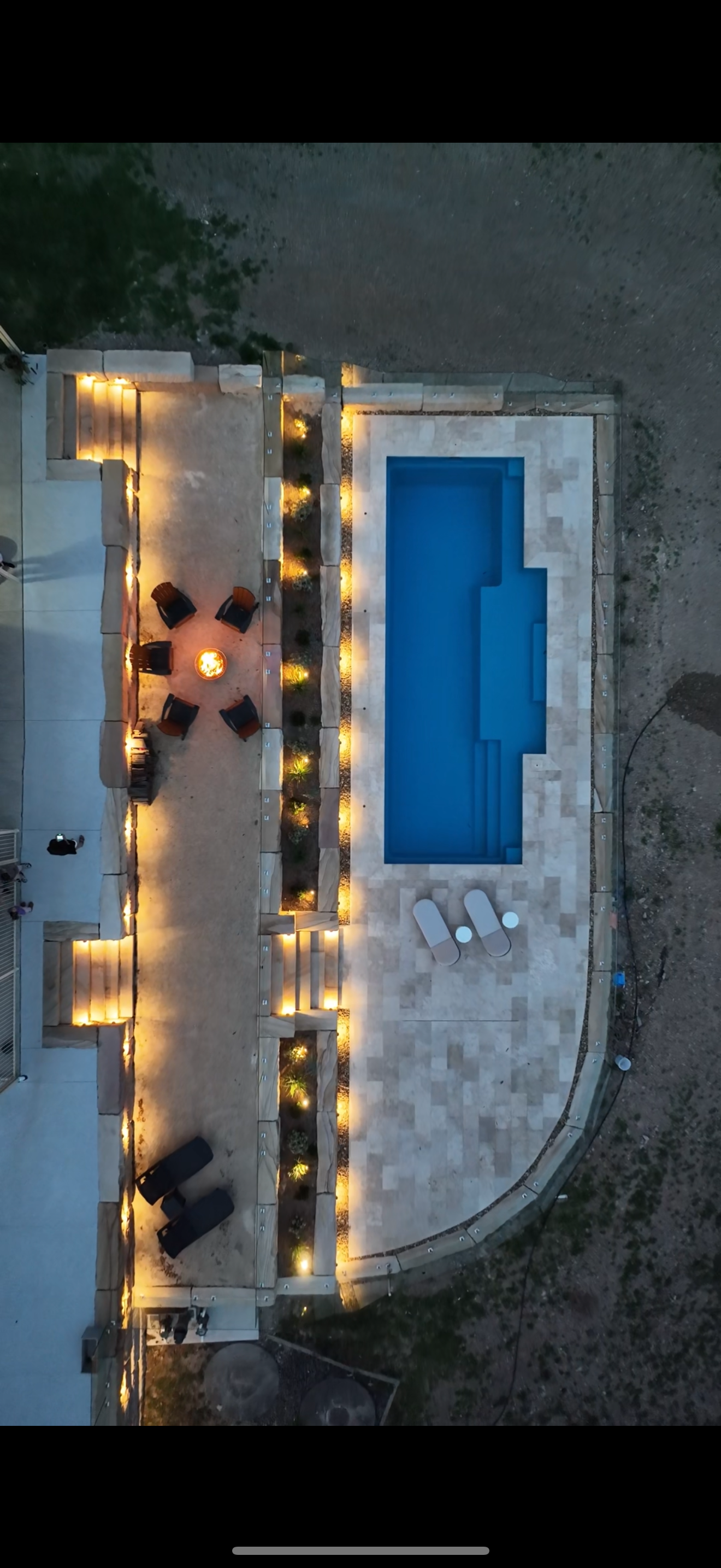 Aerial View of a Lit Poolside Patio With a Long Blue Swimming Pool — Billabong Pool Co in Smeaton Grange, NSW