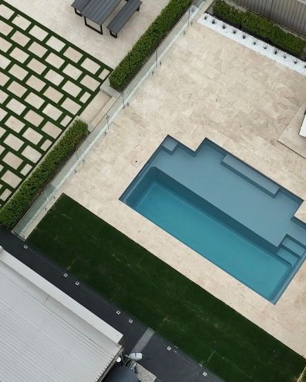 Overhead View of a Modern Backyard With a Blue Pool, Stone Patio, and Green Lawn — Billabong Pool Co in Wollongong, NSW